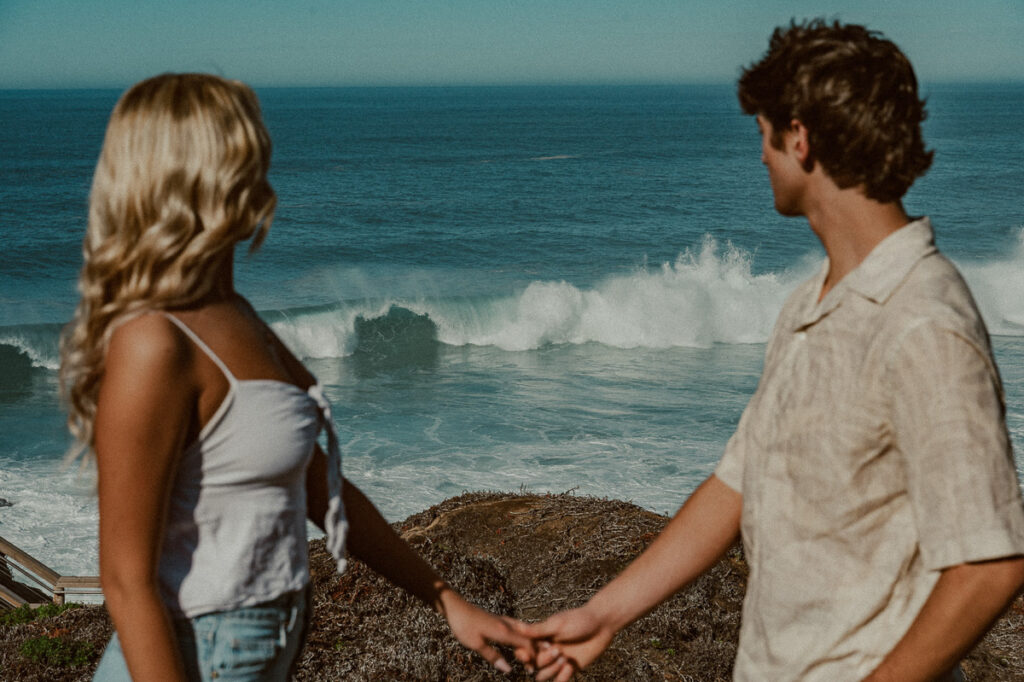 couple overlooking the ocean with waves crashing