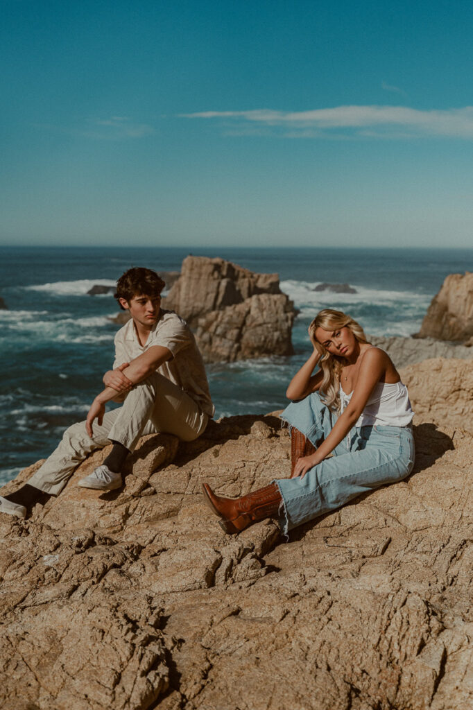 young couple on cliffs overlooking ocean