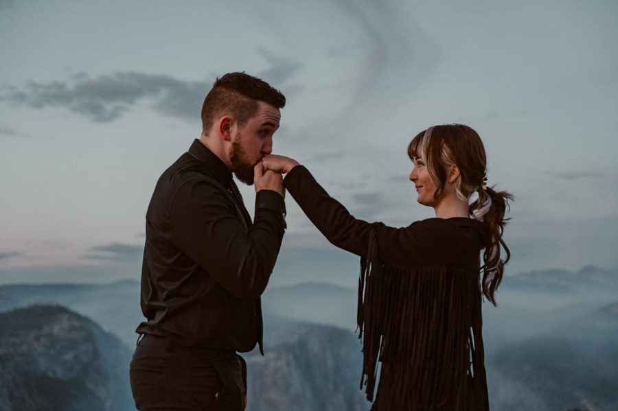 Yosemite Elopement groom kissing bride's hand at Taft Point