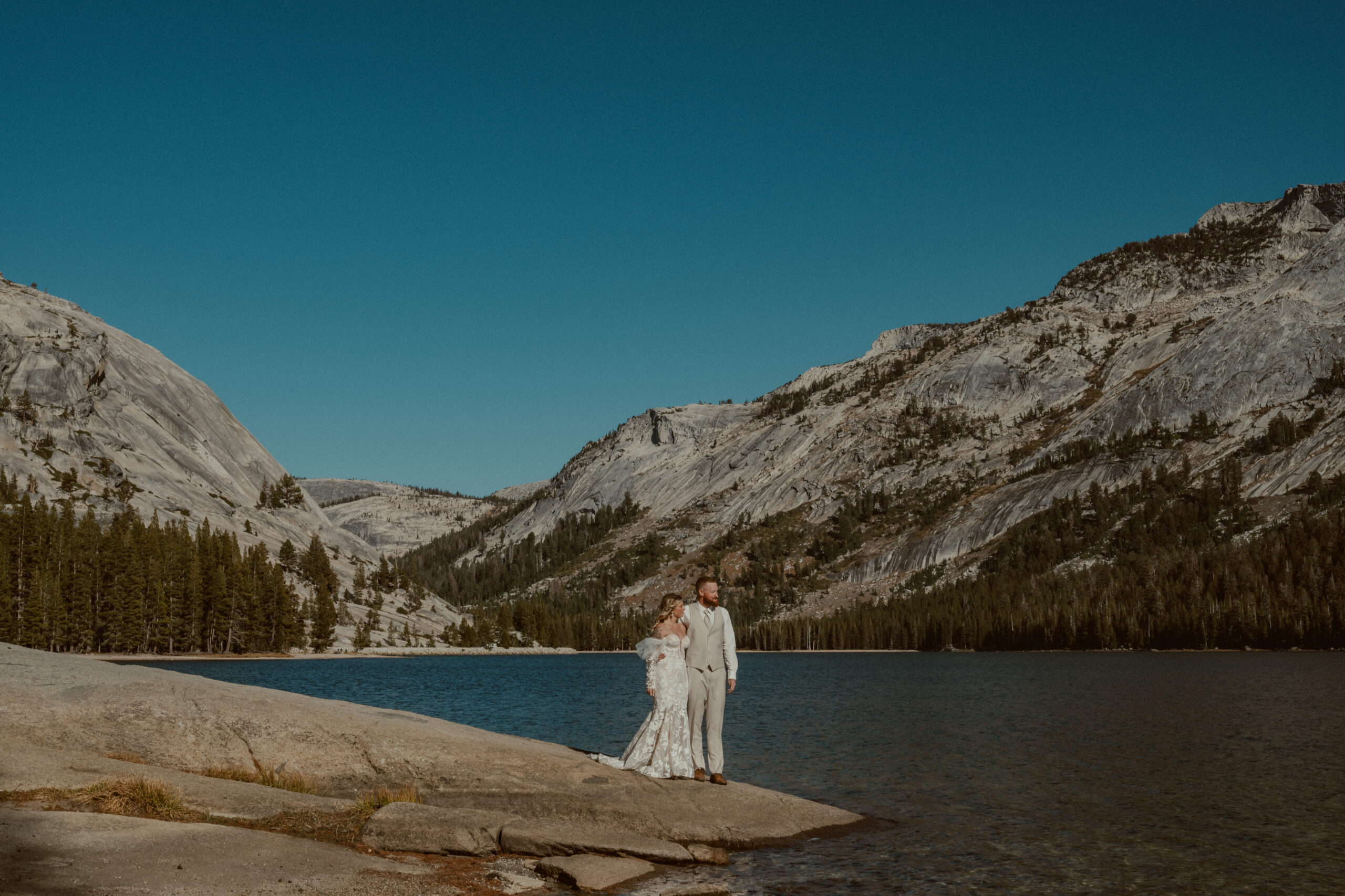 bride and groom enjoying the views at tenaya lake in yosemite during their elopement